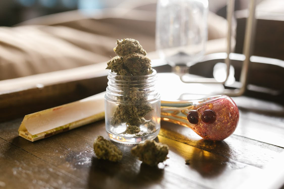  a jar of weed with a pipe