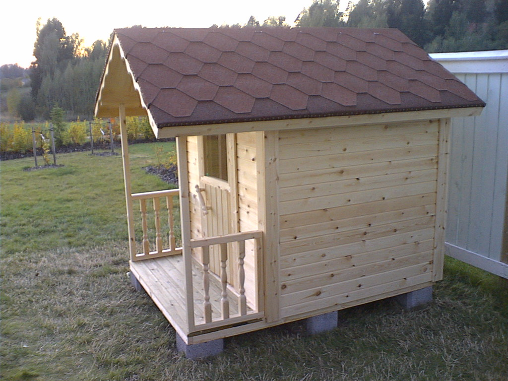 A DIY playhouse made from wooden planks and other materials. 
