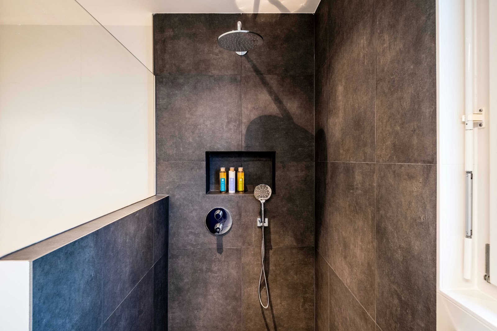 open shower with large brown tiles