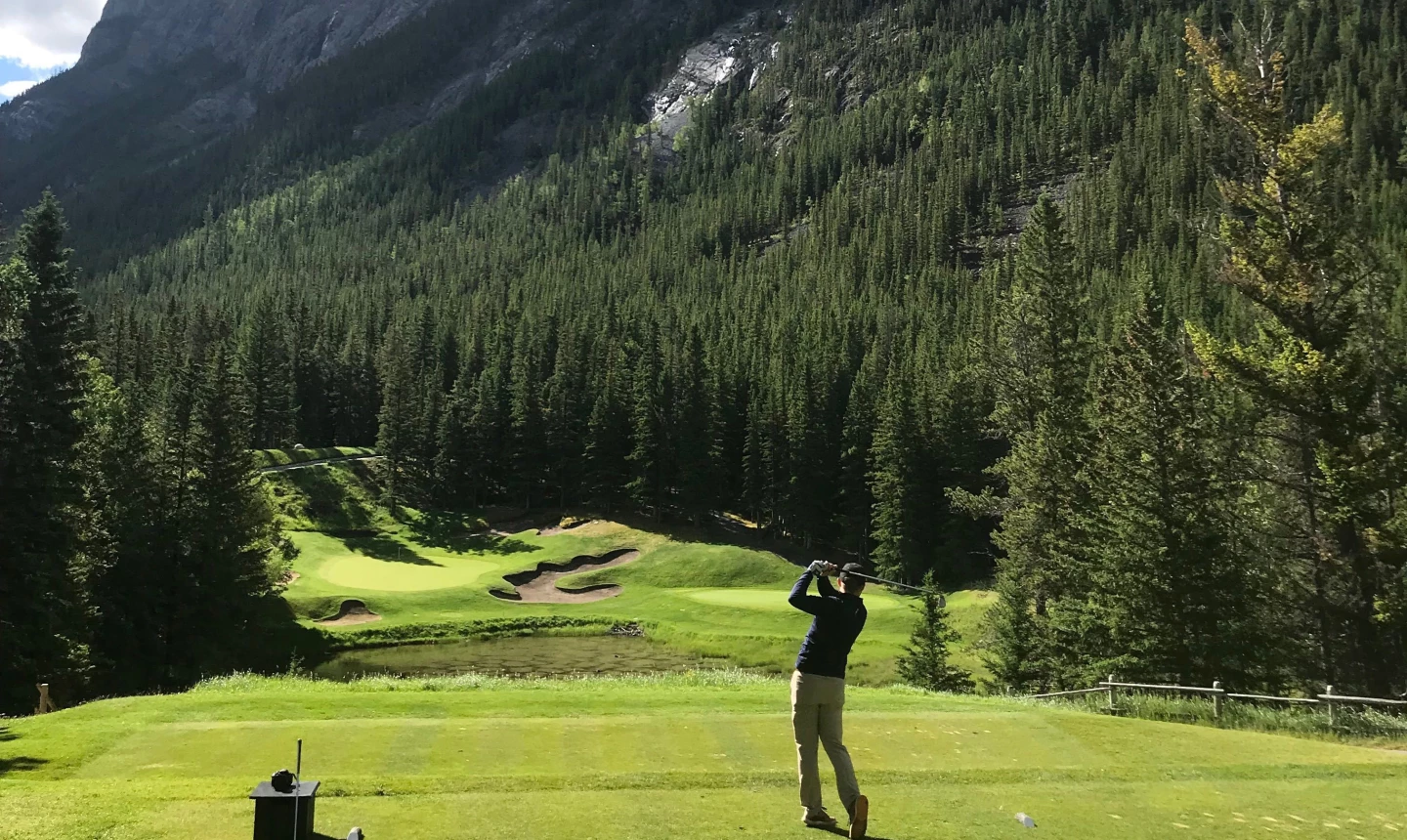 golfer hitting ball in moutains