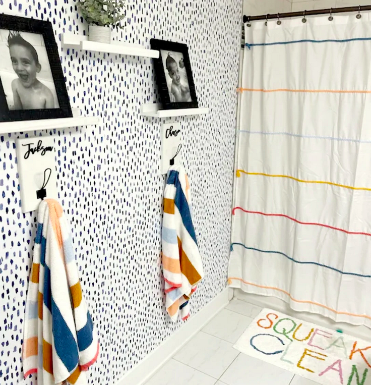 A bathroom with a shower curtain and towels

Description automatically generated