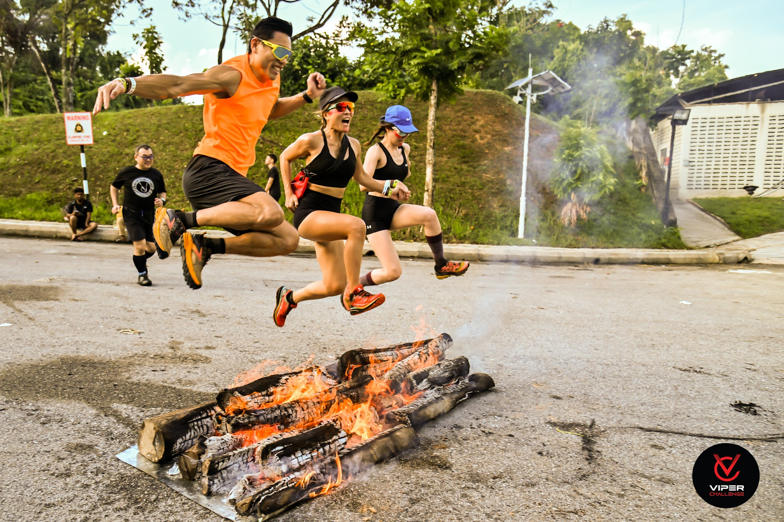 Participants Jumping Over Fire in Obstacle Course