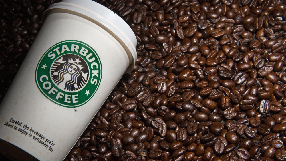 Starbucks coffee cup on coffee beans