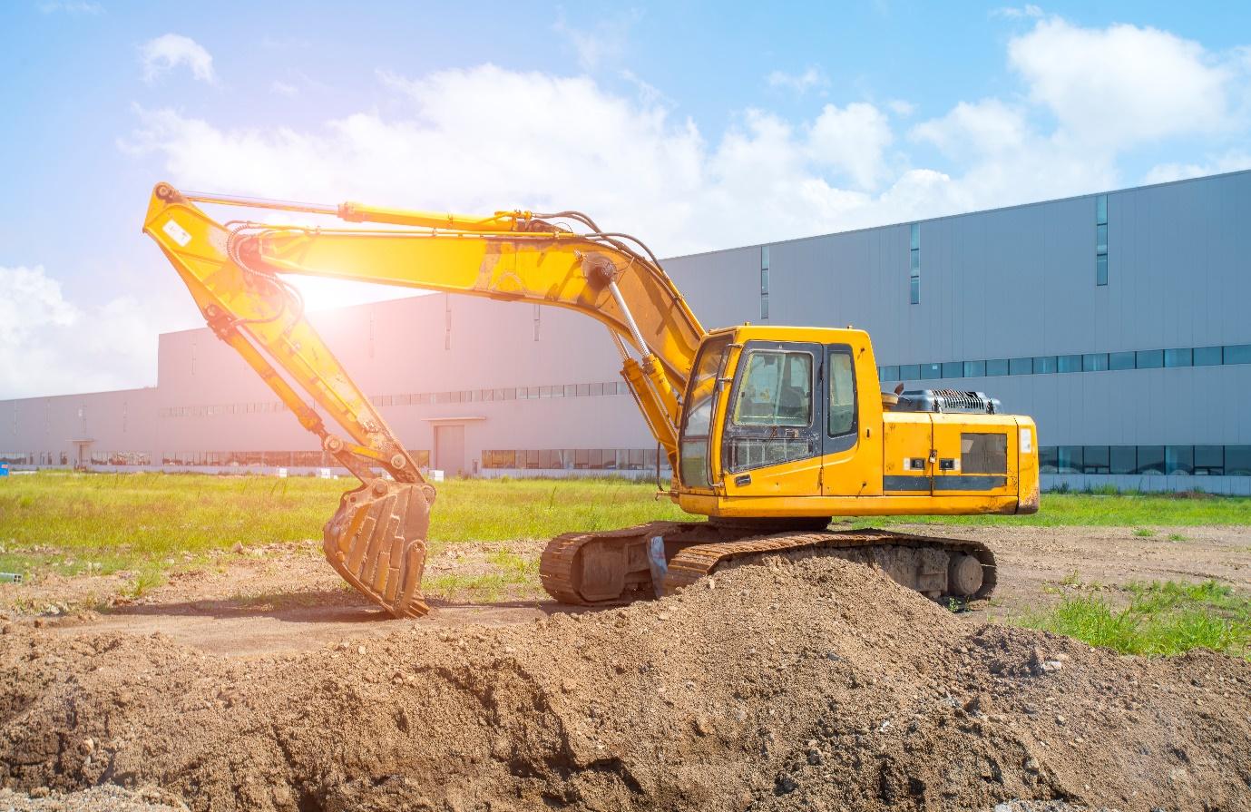 A yellow construction vehicle with a bucket on dirt

Description automatically generated