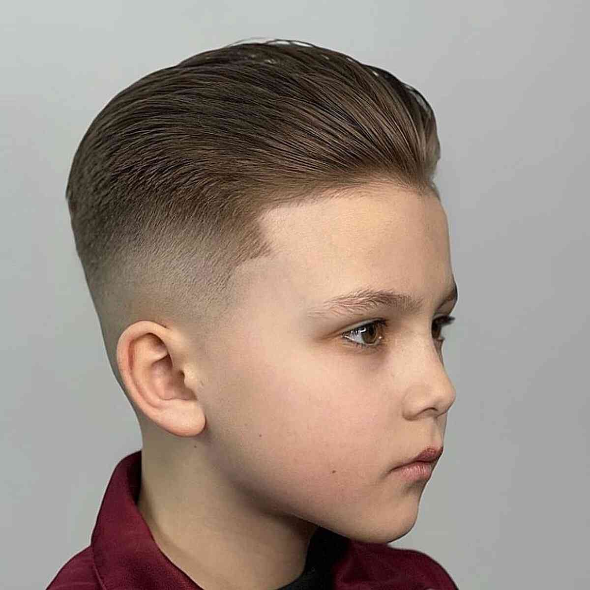 Side view of a young boy rocking the slicked back hairstyle