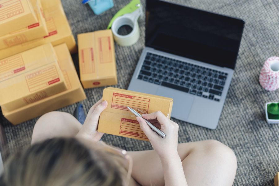 A person writing on a box