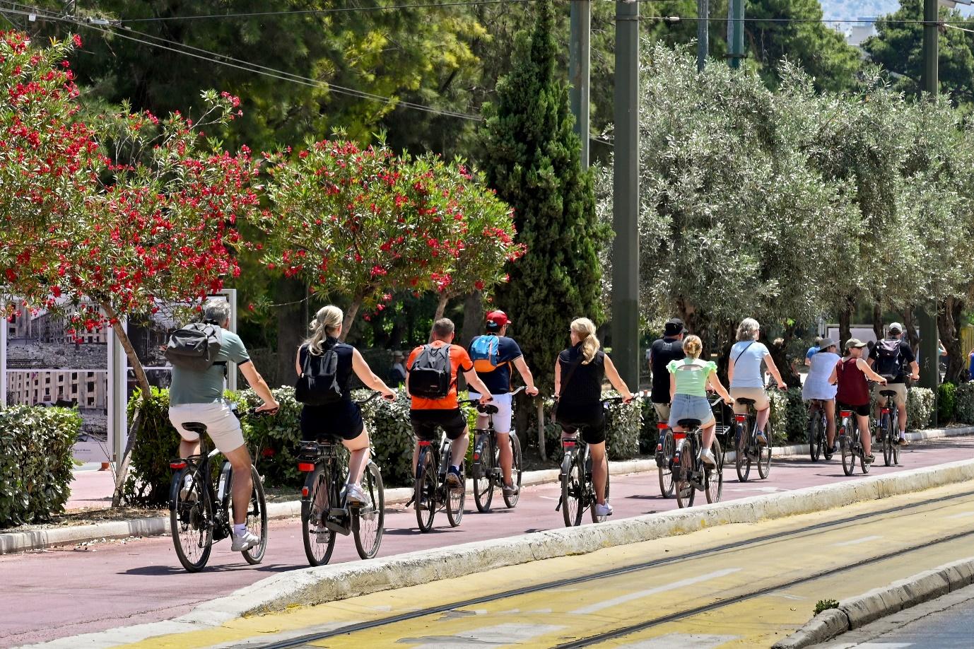 A group of people riding bicycles on a sidewalk

Description automatically generated