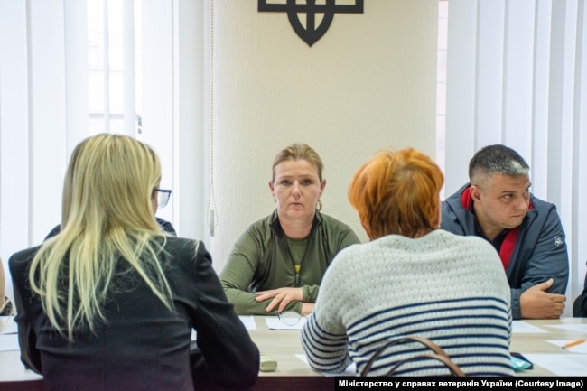 Міністерка у справах ветеранів Юлія Лапутіна (посередині) на зустрічі з родинами полеглих воїнів. Київ, жовтень 2023 року