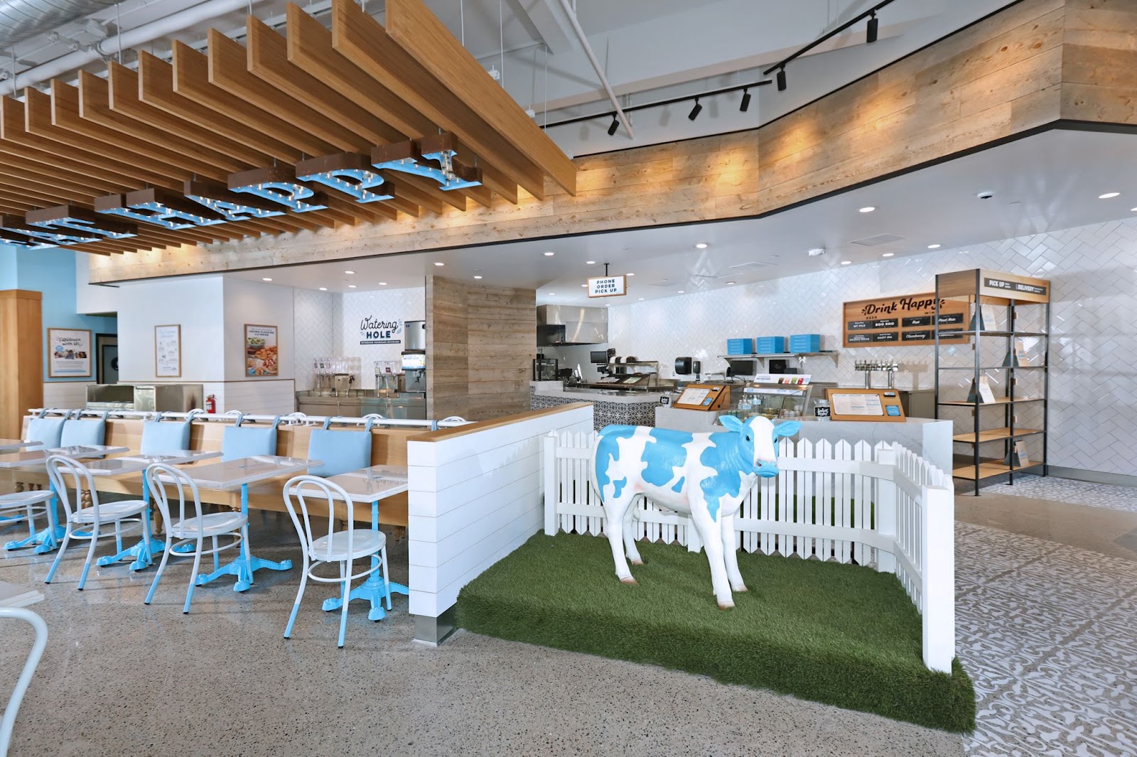 Interior view of Mendocino Farms with seating, counter, and blue and white decorative cow