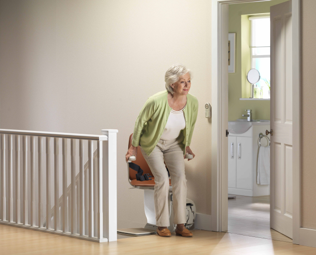 A lady using a Stannah stairlift