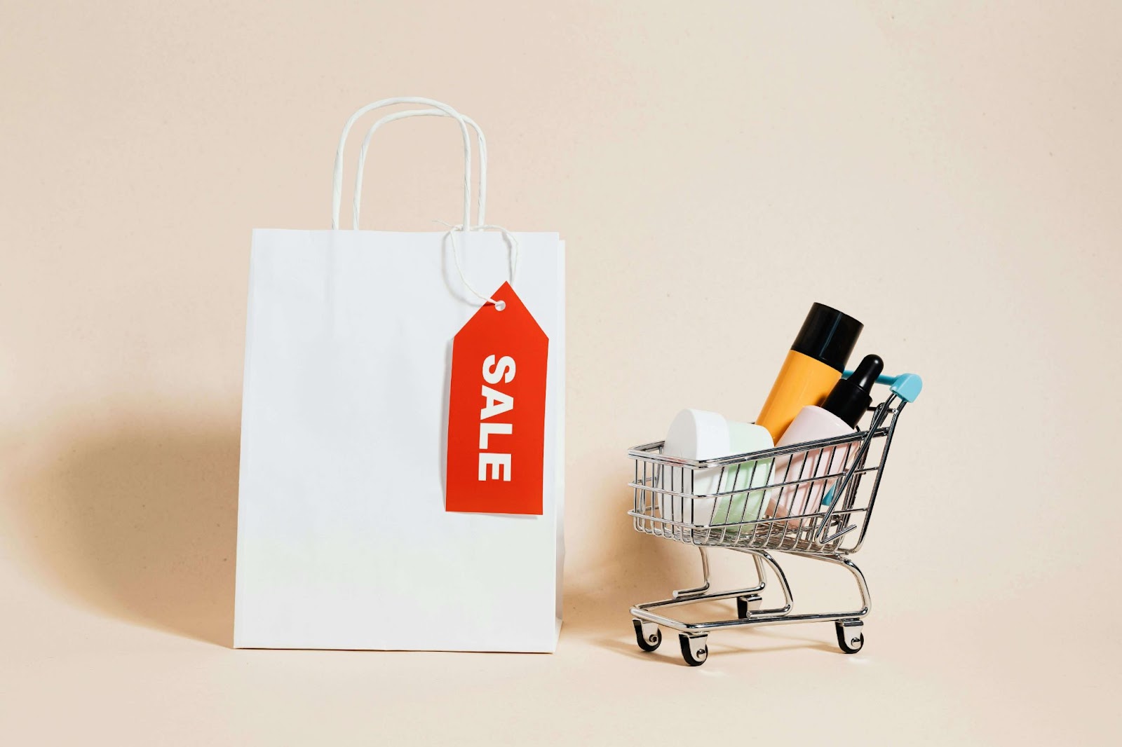 Bolsa de compras con etiqueta de 'SALE' junto a un carrito de compras en miniatura lleno de productos de belleza, simbolizando ventas efectivas por WhatsApp