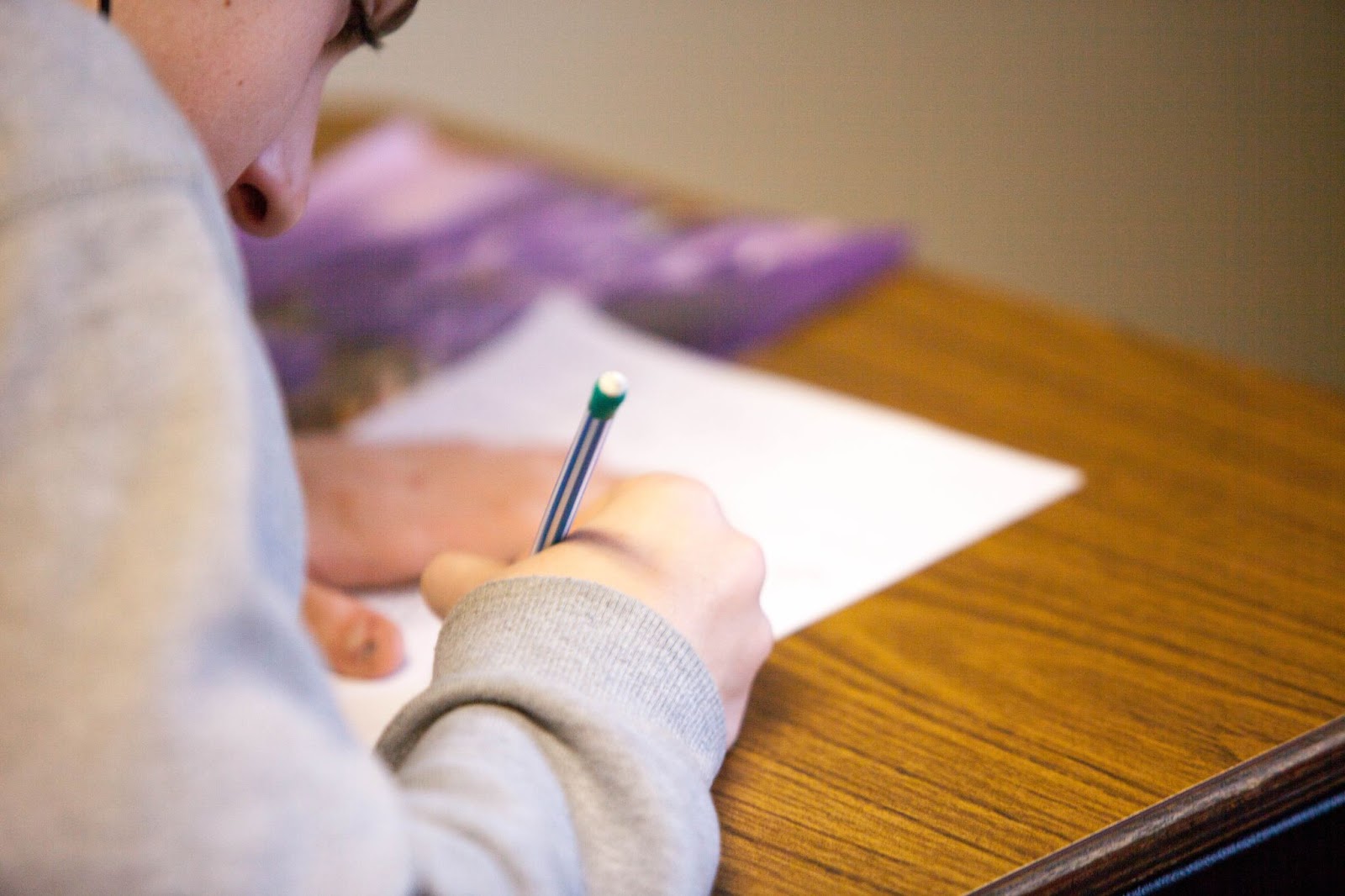 Student taking a writing test with a led pencil - Navigating Racial Bias in Testing