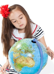 A child looking at a globe

Description automatically generated