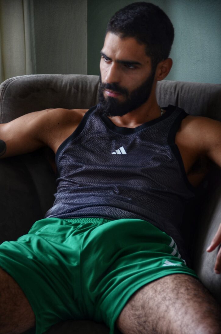 karim yoav smirking while showing off his erect cock through his green athletic shorts