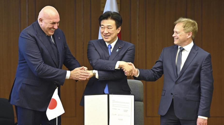 Britain's Defense Minister Grant Shapps, right, Italy's Defense Minister Guido Crosetto, left, and Japanese Defense Minister Minoru Kihara, center, shake hands after a signing ceremony for the Global