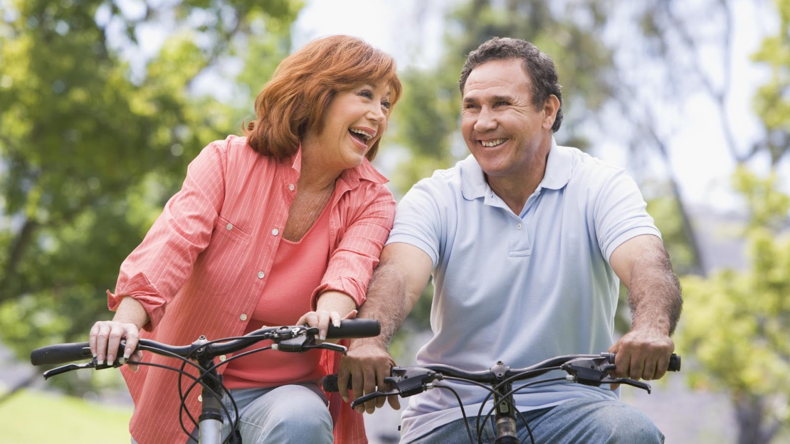 older couple riding bikes outside