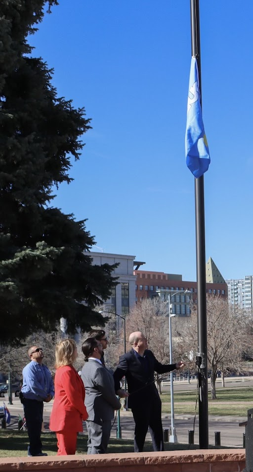 Governor Polis raises the Pueblo flag outside the State Capitol alongside Pueblo legislators.