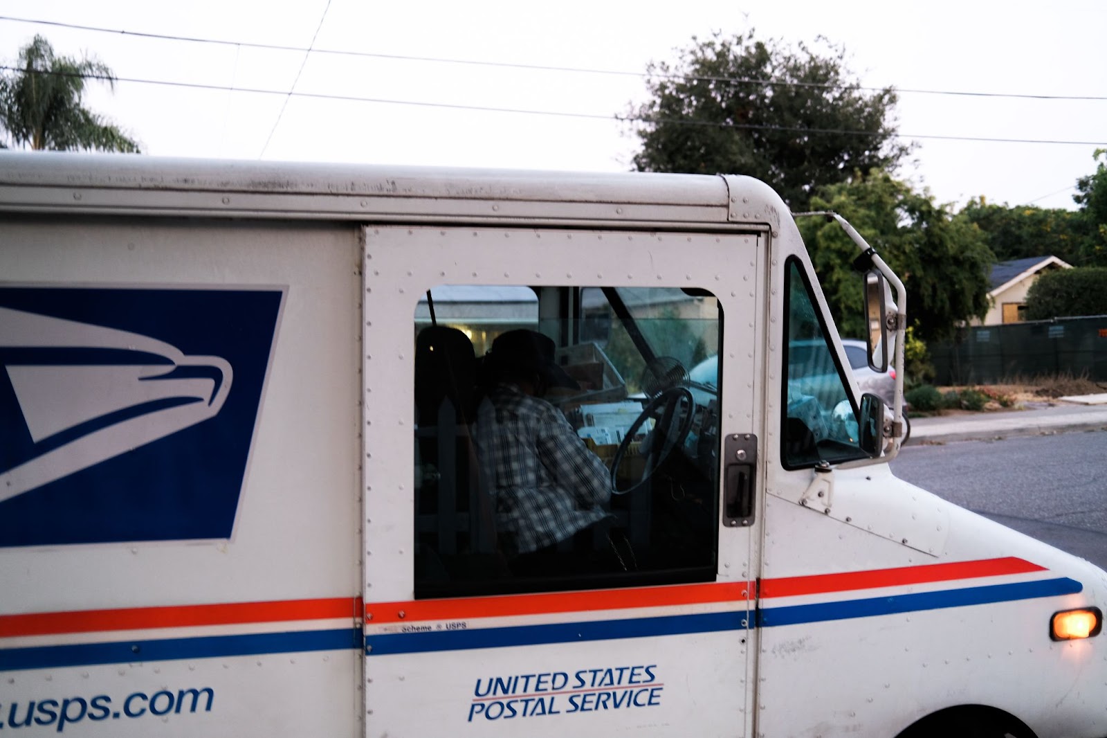 A mailman deliverying letters using the USPS Services.