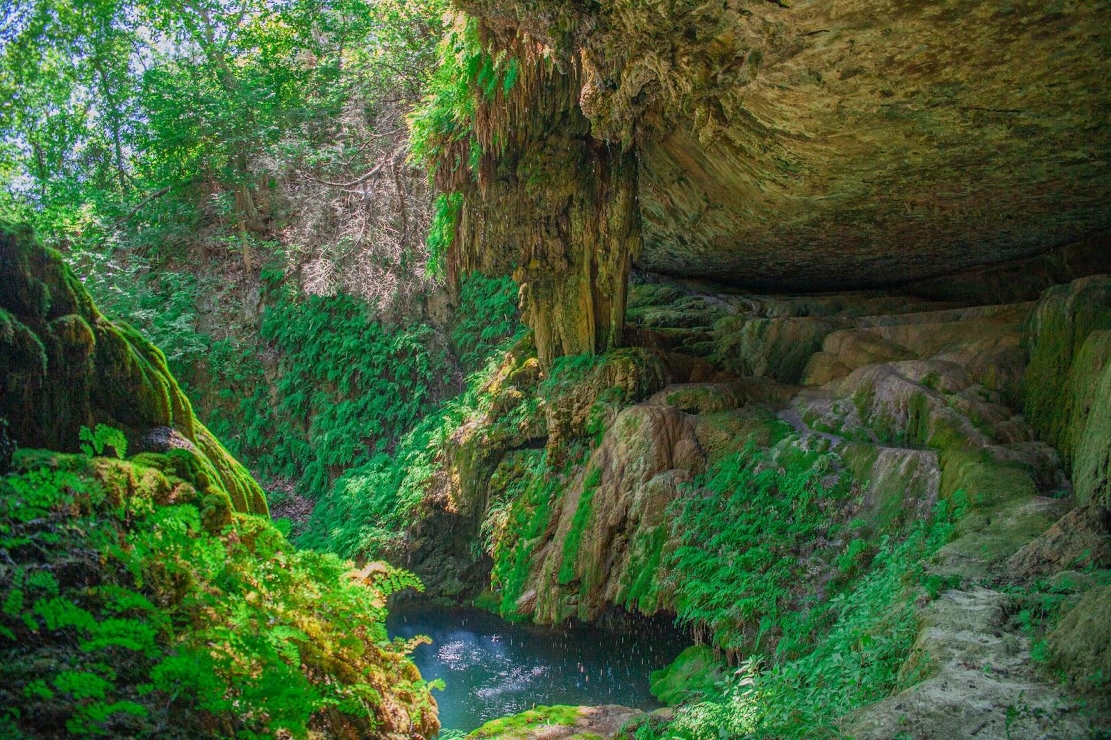 a cave with a pond and a rock formation