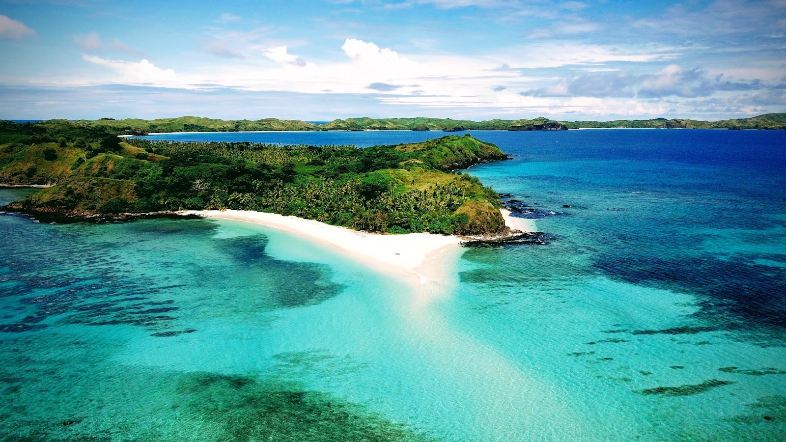 An aerial photograph showcasing the scenic beauty of the Yasawa Islands, with turquoise waters, lush greenery, and sandy beaches.