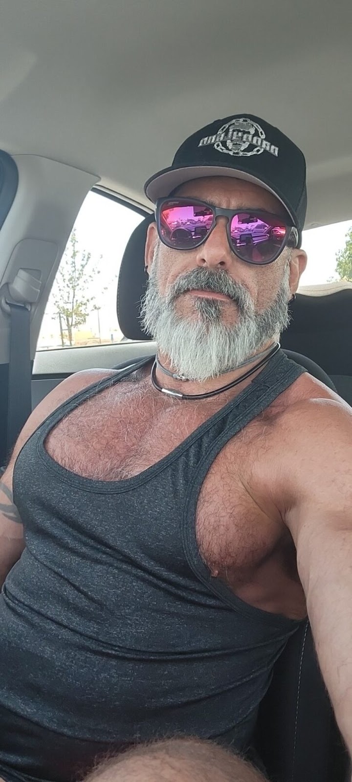 Lawson James taking a selfie in the car in a tight grey tank top and his hairy nipple poking out the side of the shirt