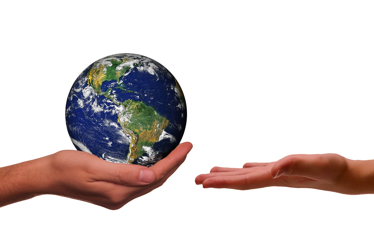 A hand holding onto planet Earth. Image by Gerd Altmann from Pixabay.