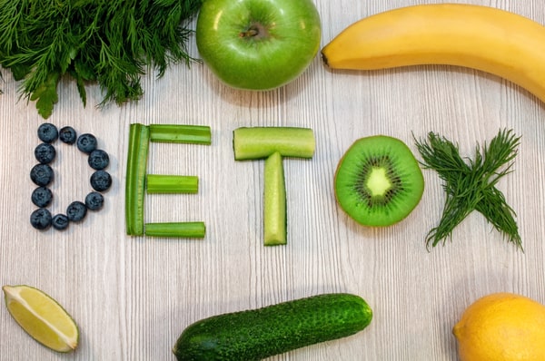 Different kinds of fruits and herb slices spelling out the word "DETOX"