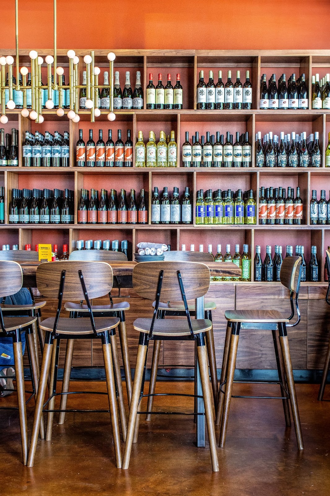 Bar seats and display of wine bottles inside Postino