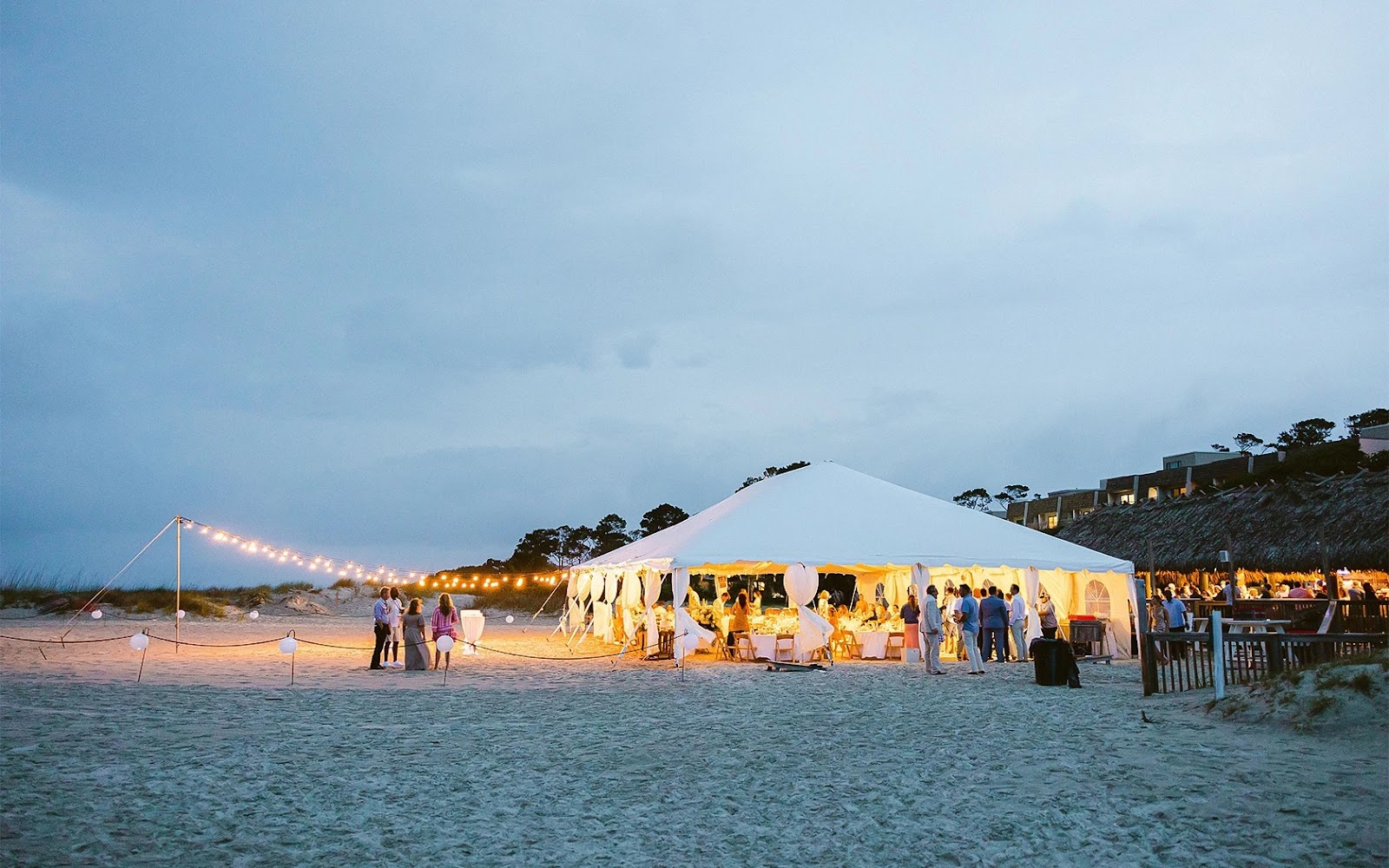 Tent on the beach lit with twinkle lights for a wedding at The Beach House in Hilton Head, SC