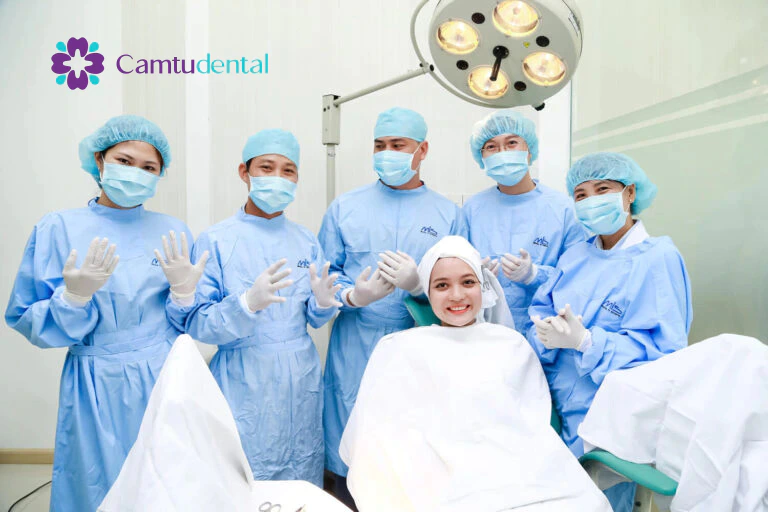 Đội ngũ chuyên gia nha khoa thân thiện trưỡ khi tiến hành cấy ghép Implantvà bệnh nhân mỉm cười trong phòng điều trị tại Nha khoa cẩm Tú Quận 1