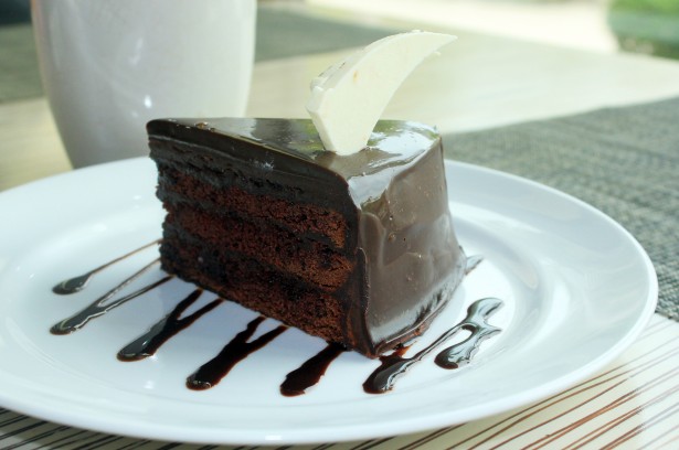 さらに乗ったコーティングされたチョコレートケーキの画像