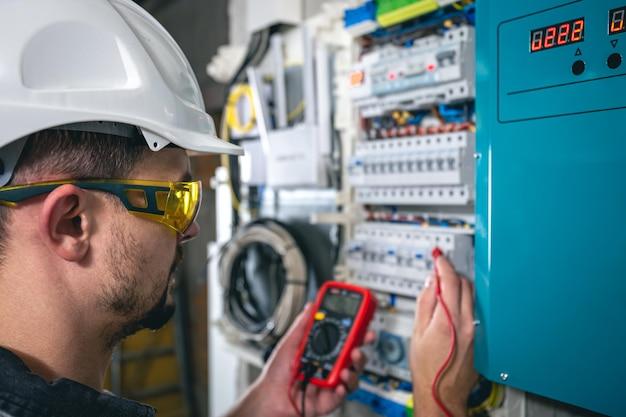 Técnico elétrico trabalhando em um quadro de distribuição com fusíveis