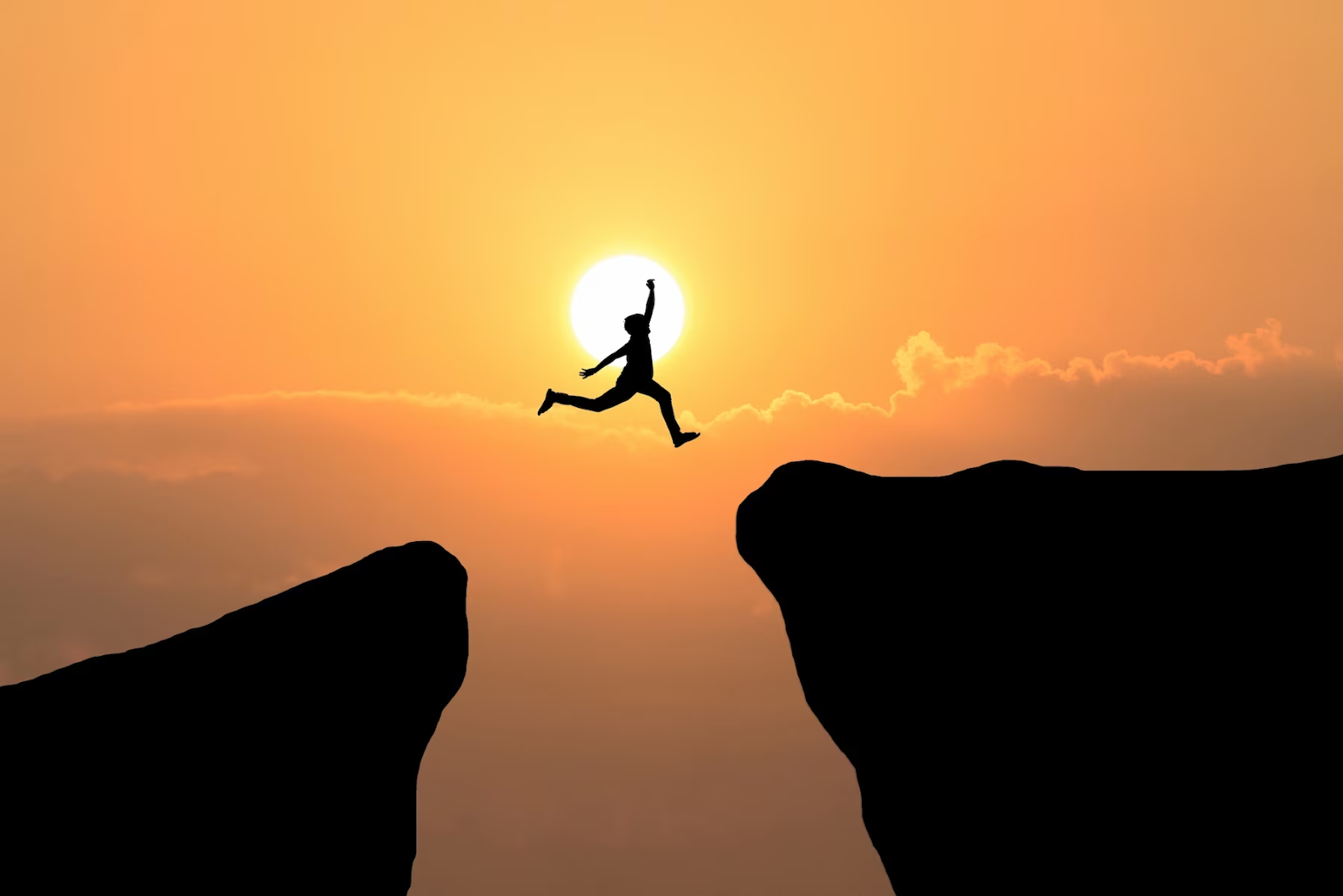 A boy jumping through the gap between hills.