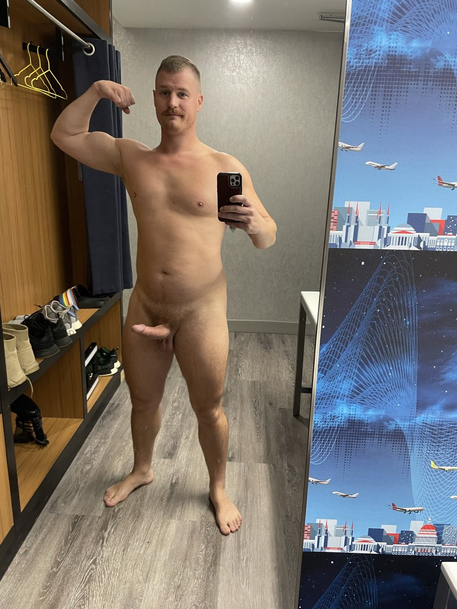 Jordi Massive taking a naked mirror selfie with a hard cock flexing his biceps and smiling in the mirror