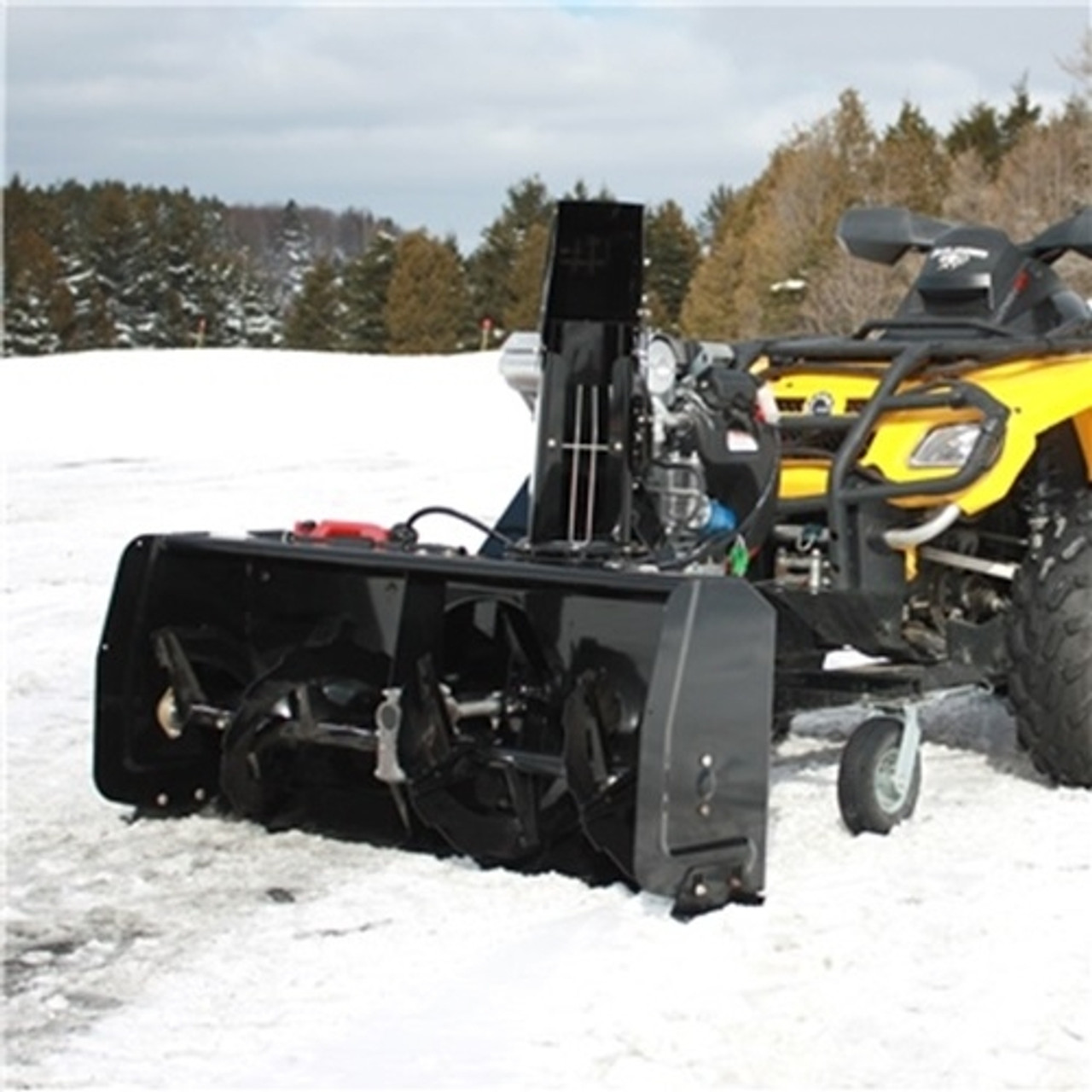 A front-oblique image of a Polaris Sportsman Snowblower by Bercomac, installed on an ATV and parked on snowy terrain.