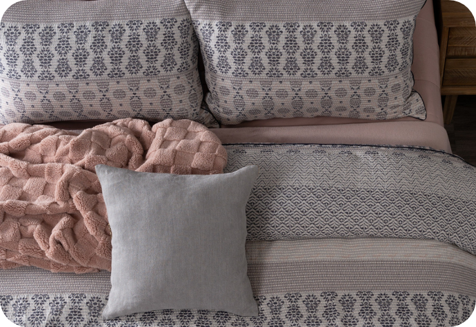 Notre housse de couette Raina texturée présentée sur un lit agrémenté d'accessoires.