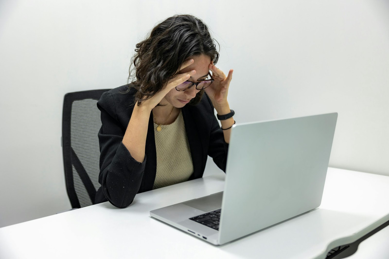 Woman with Glasses Looking at a Laptop Screen, Covering Her Face