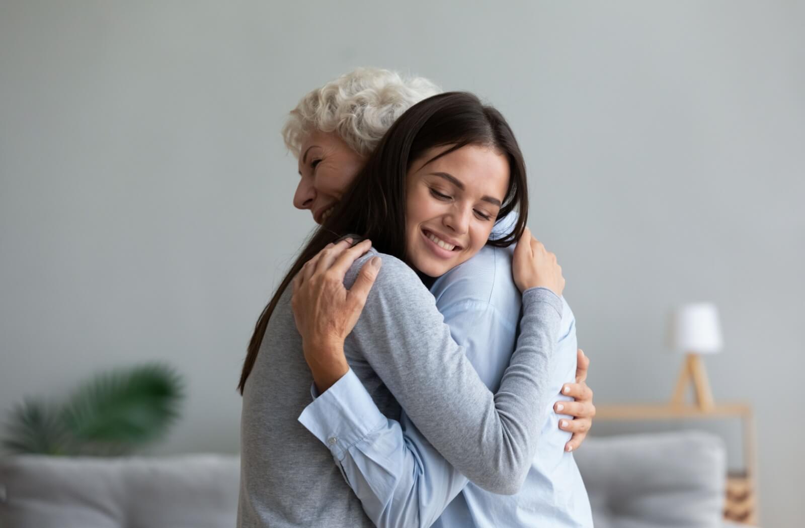 A woman hugging her older adult mother lovingly.
