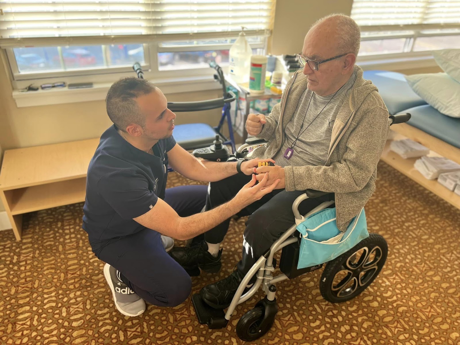 A physical therapist helping a senior citizen in a wheel chair.