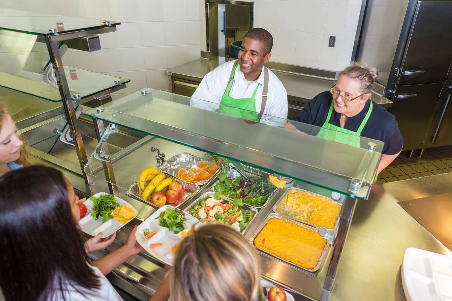 Dining hall staff distributing meals during lunch time at summer camp