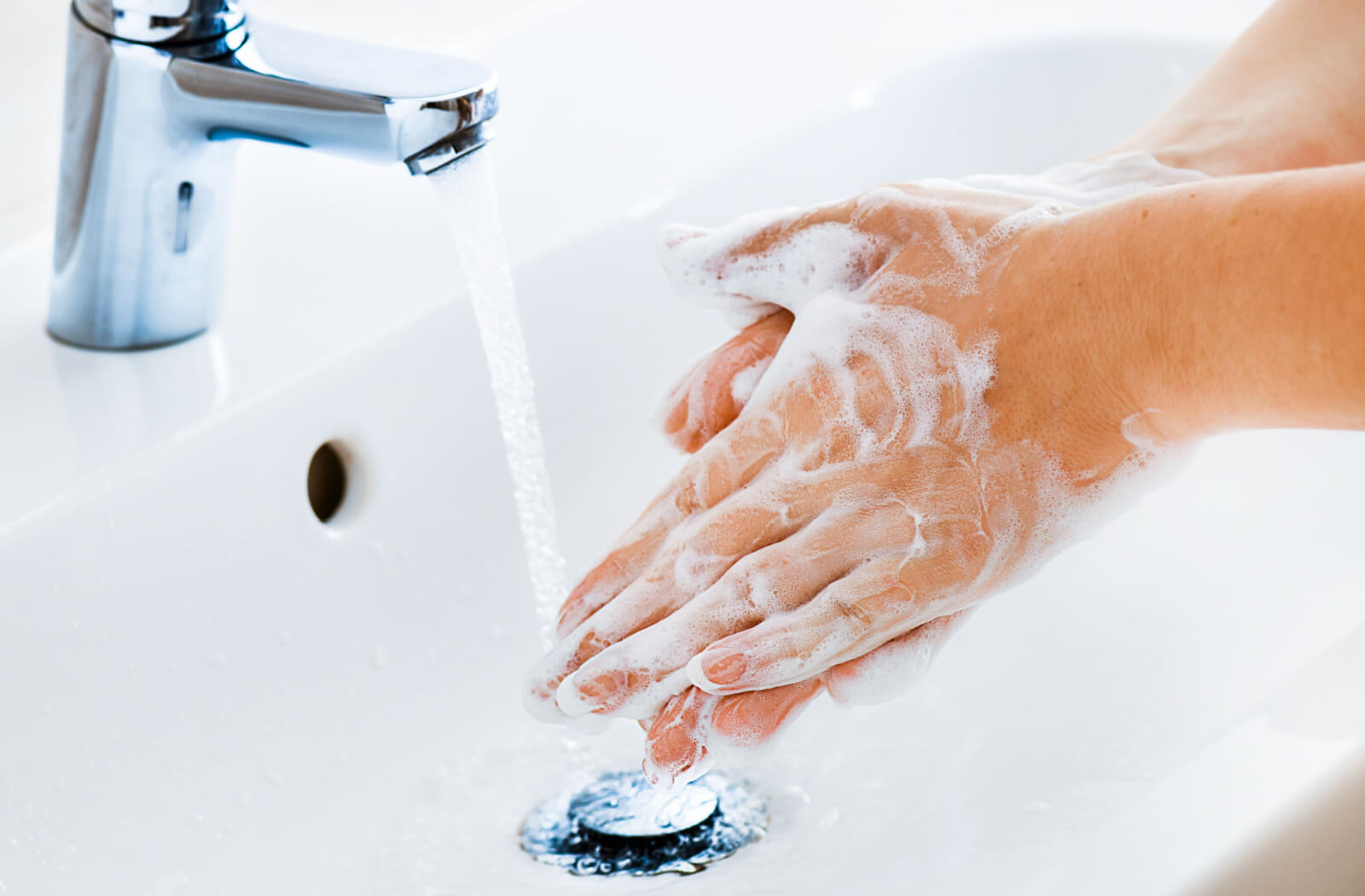 A close-up of someone washing their hands with soap and water