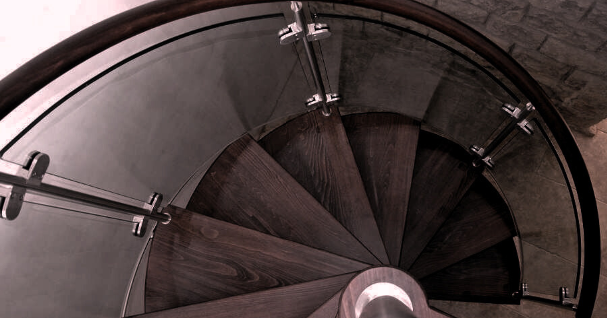 A spiral staircase with a wooden railing, featuring a curved winder stair glass rail.