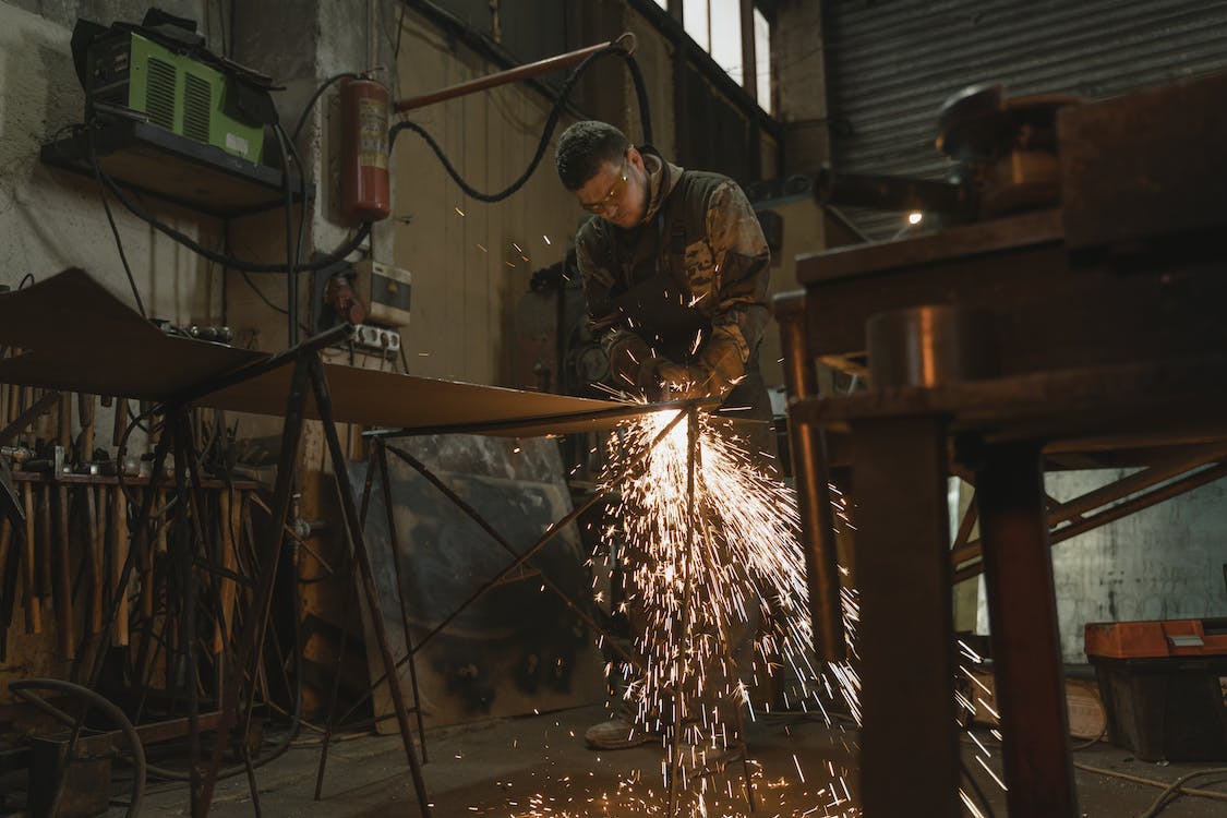 Free Man in Safety Glasses Welding a Metal Bar Stock Photo