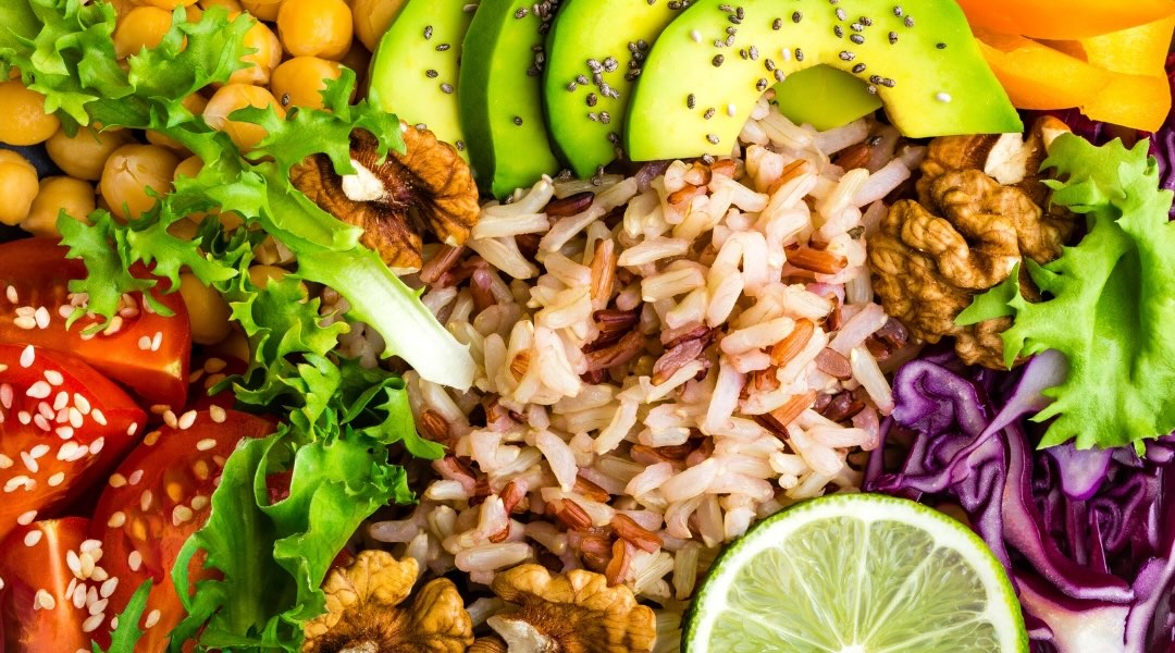 brown rice, avocados, lime, red cabbage, bell pepper, walnuts, and chickpeas in close-up