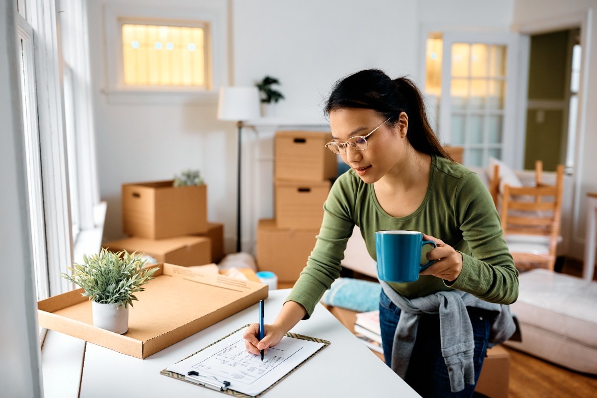 woman-making-to-do-list-while-moving-out-of-apartment