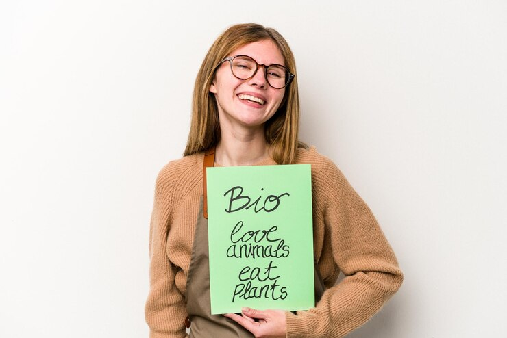 Happy Girl Picking Poster in Hand of Insta Bio that Says Love Animals, Eat Plants!