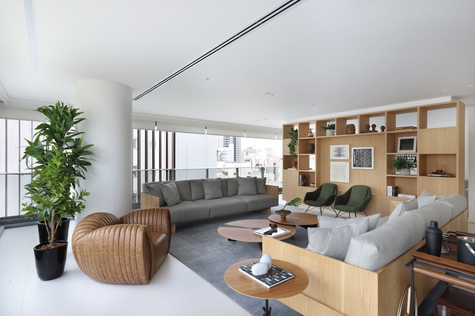 Foto de um apartamento decorado com paredes brancas, sofá e tapete, com uma estante em madeira.cinza