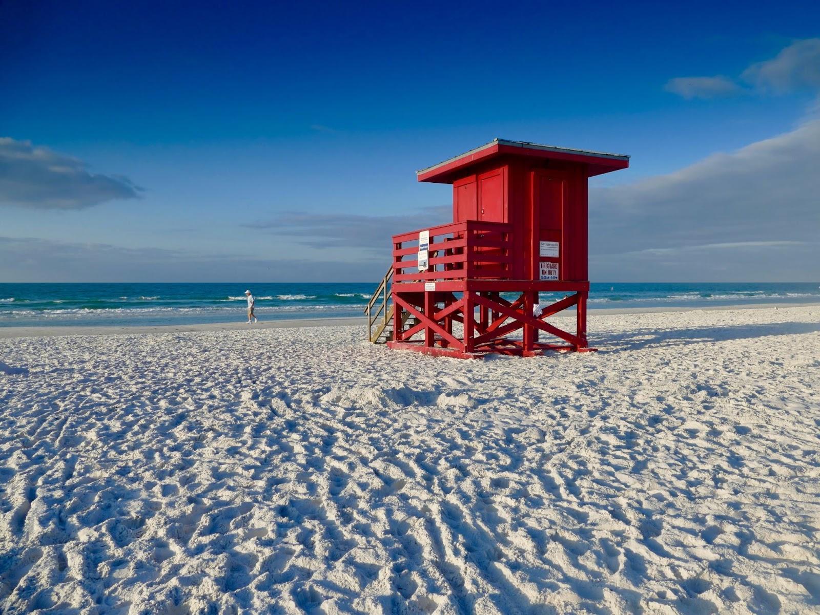 Fort Myers vs. Sarsota: Which is the better beach town- beach in Sarasota with red lifeguard stand. 