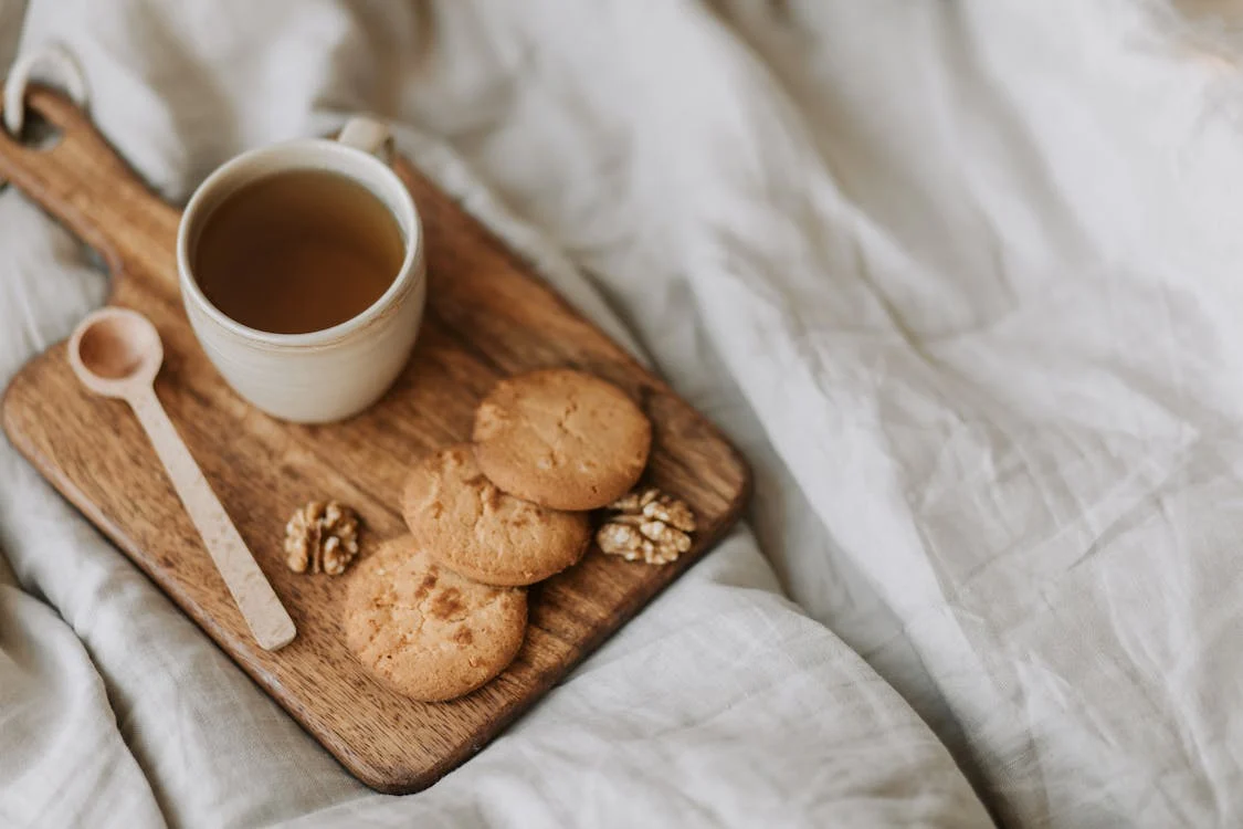 A mug of tea and holiday snacks on a wooden board