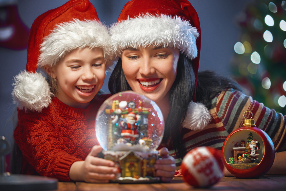 mom and daughter looking at a snow globe